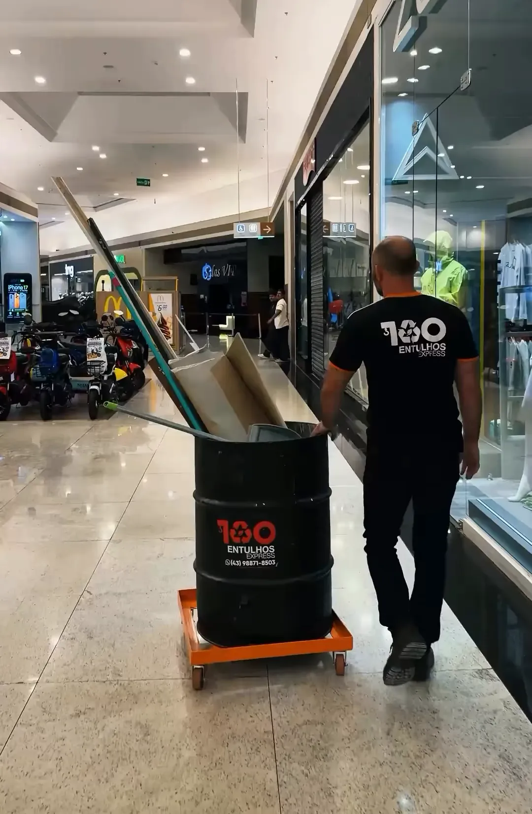 Funcionário empurrando o coletor pelo corredor do Catuaí Shopping