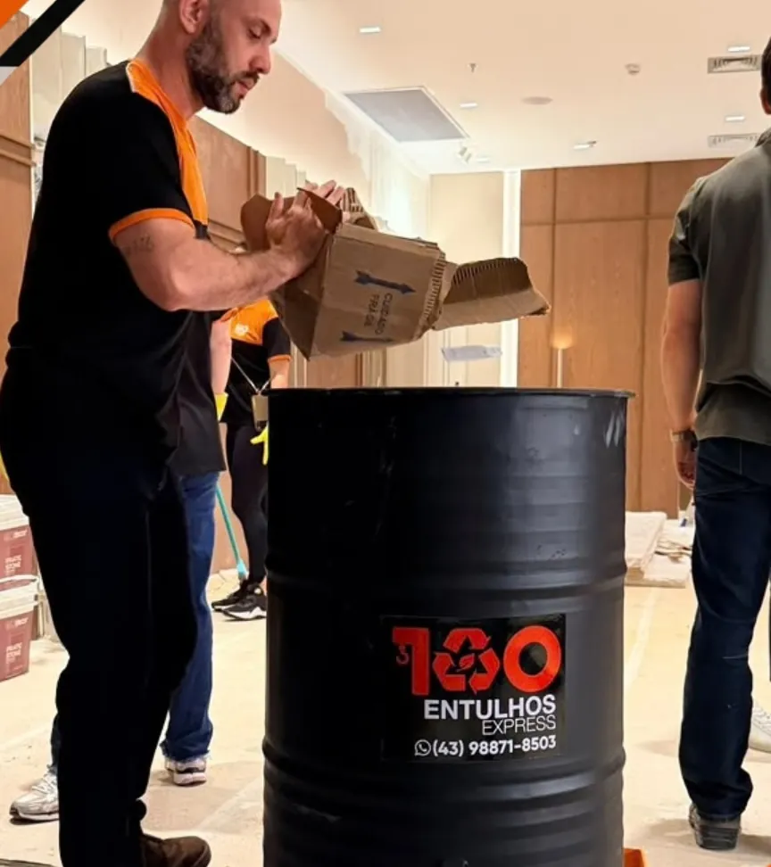 Funcionário da 100 Entulhos jogando sobras da obra no coletor dentro de uma loja do Catuaí Shopping