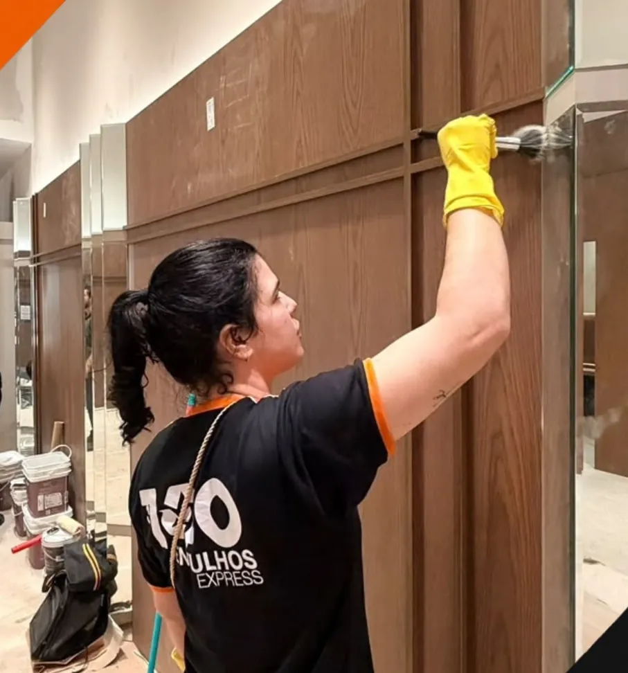 Funcionária da 100 Entulhos limpando os painéis de uma loja depois da obra