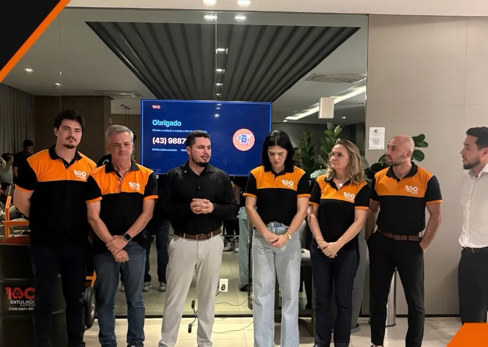 Equipe da 100 Entulhos Express Londrina de uniforme laranja e preto na inauguração